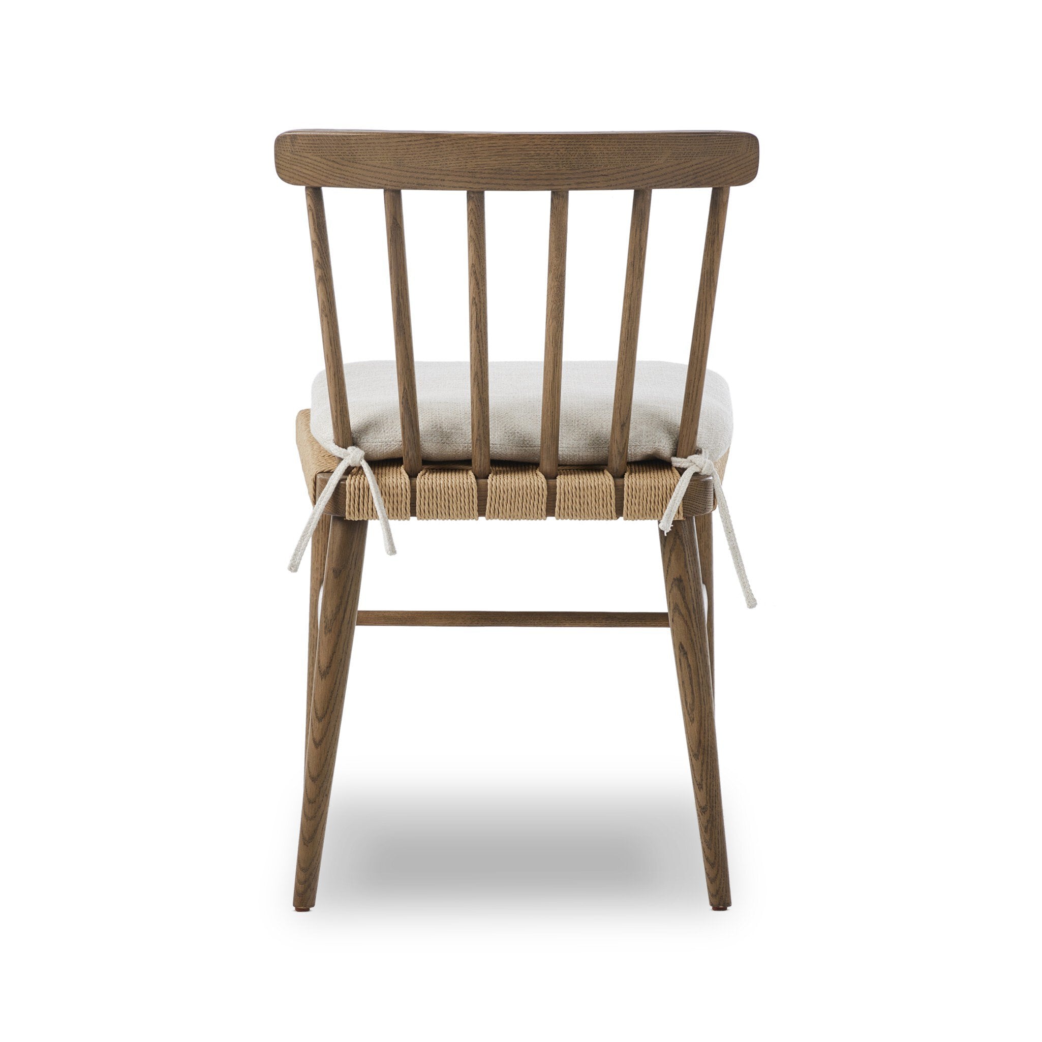 Wooden chair a spindle back, grid-woven seat, and a white cushion on a white background.