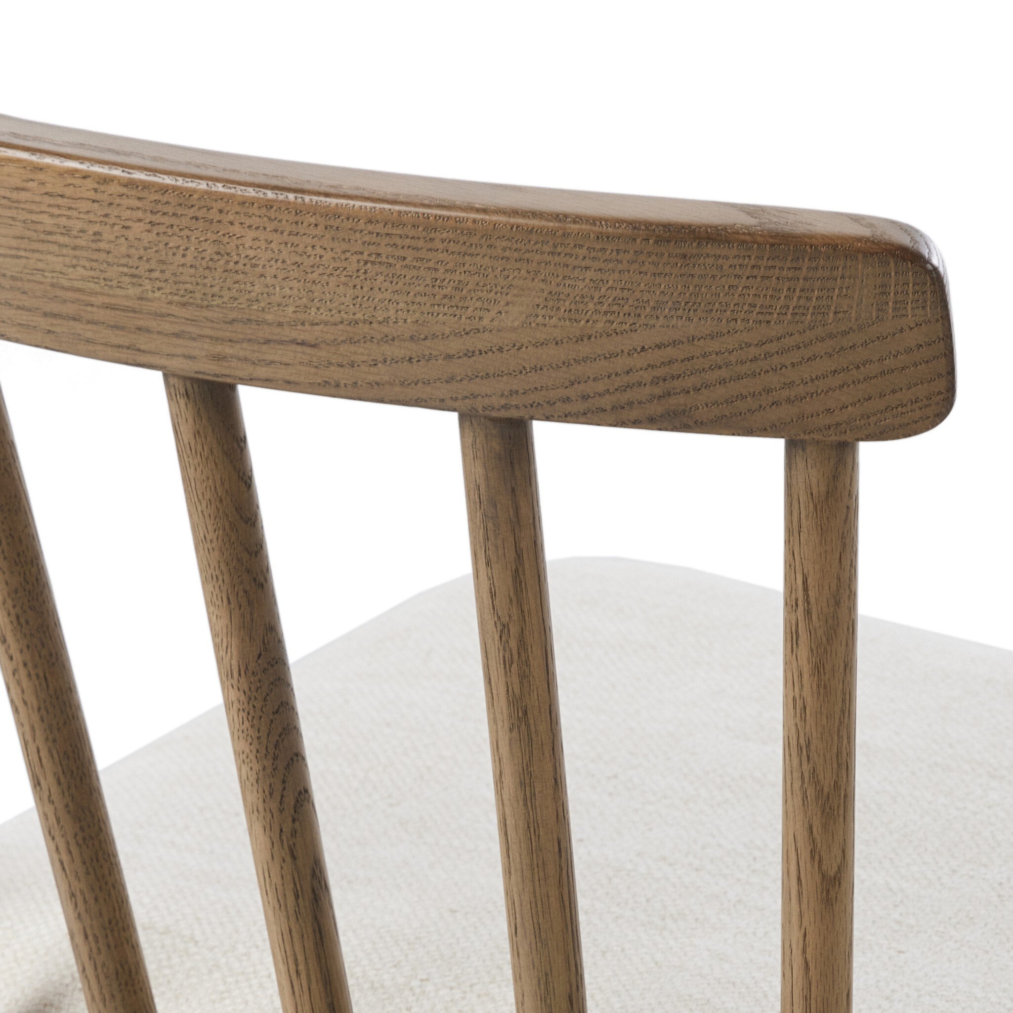 Close-up of a wooden chair with a white cushion on a white background