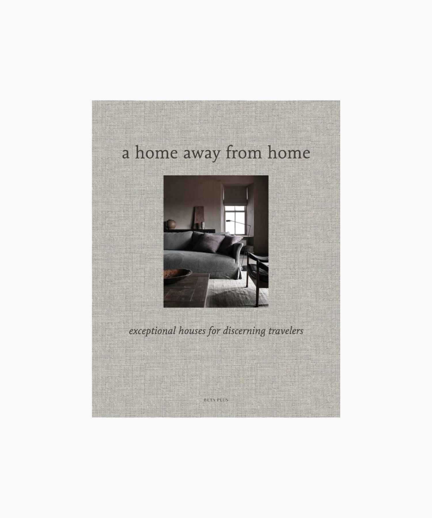 A cover of "A Home Away from Home" book; showcases a cozy, elegant living room with a gray sofa and large window, evoking warmth and sophistication. | S.W. Home