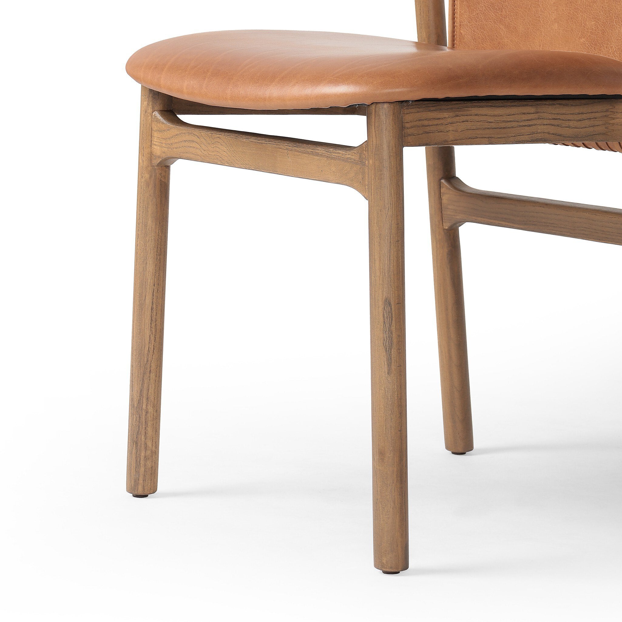 Close-up of a wooden chair with a brown leather seat on a white background