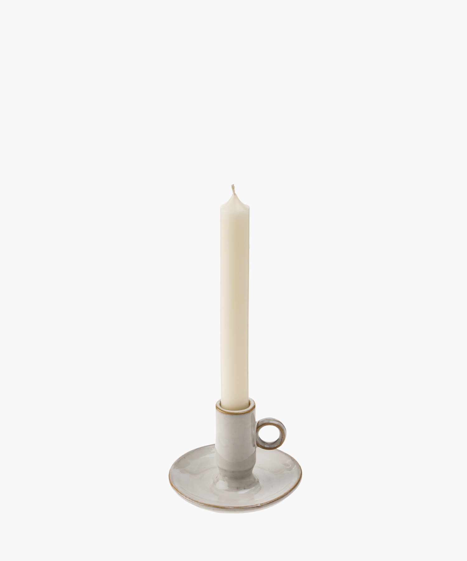 A tall, unlit white candle stands in a simple, round ceramic holder with a loop handle, against a white background, suggesting elegance and simplicity. | SW Home