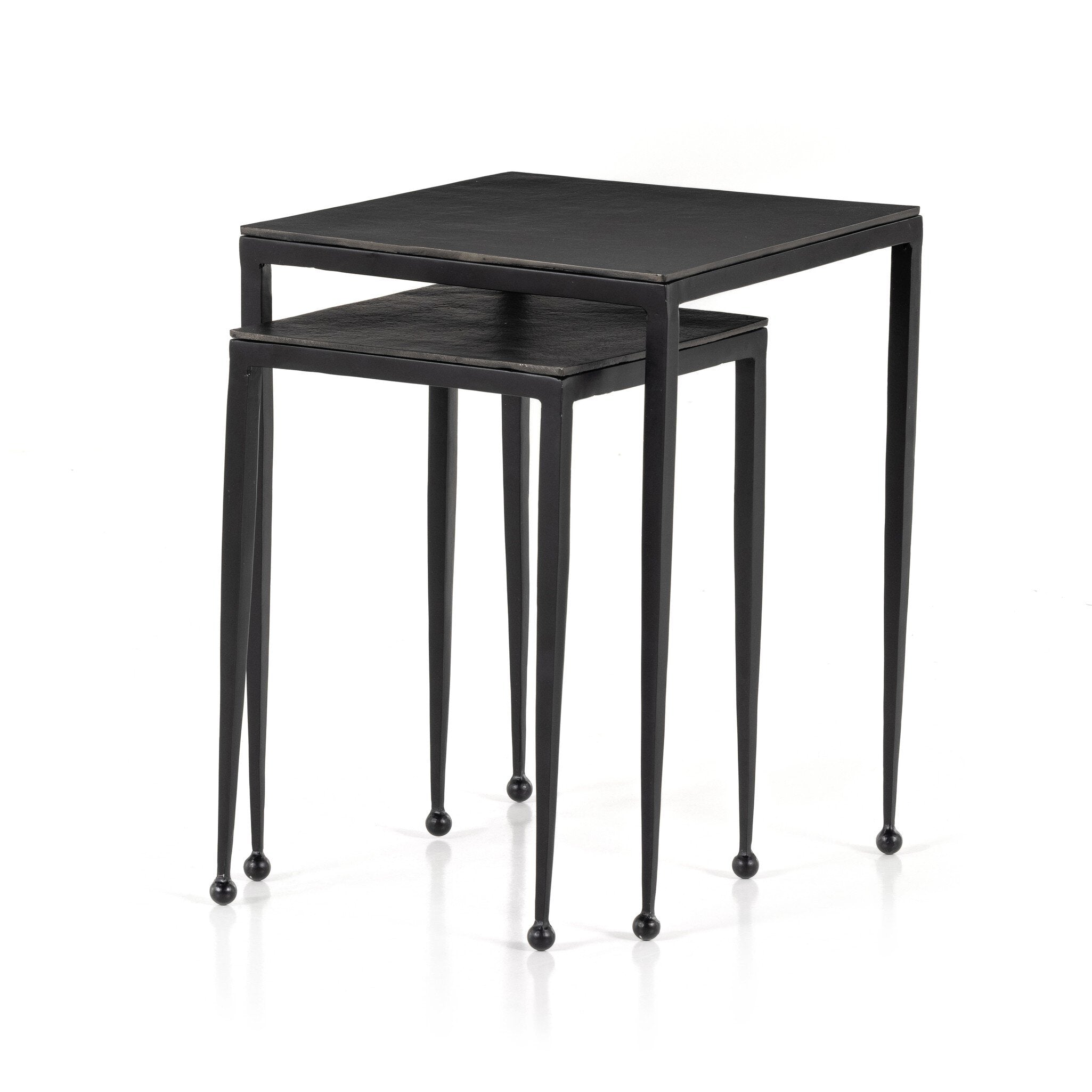 Two black nesting tables with tapered legs and squared off aluminum tops on a white background.