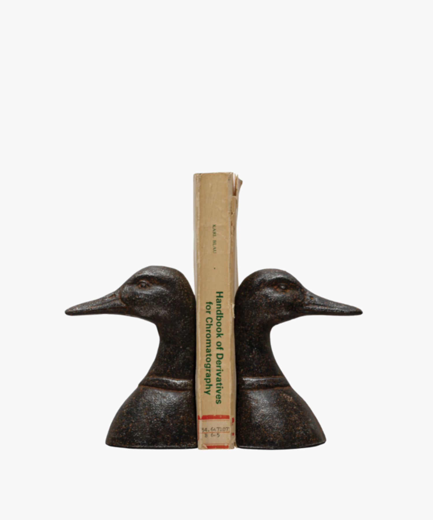 Two bronze duck head bookends face opposite directions with a book in the middle against a white background. They feature detailed textures, conveying a classic and elegant tone. | SW Home