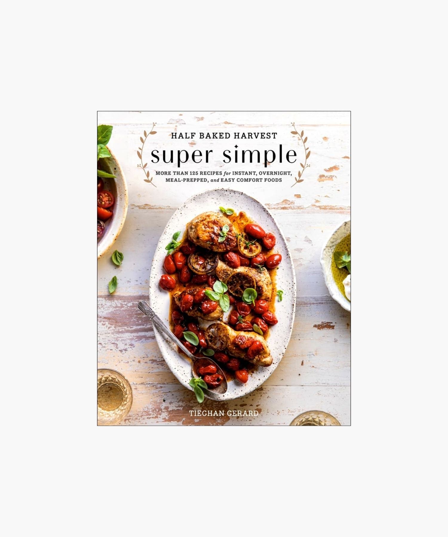 Cookbook cover titled "Half Baked Harvest: Super Simple" by Tieghan Gerard, featuring a plate of roasted chicken with cherry tomatoes and herbs on a rustic table. | S.W. Home