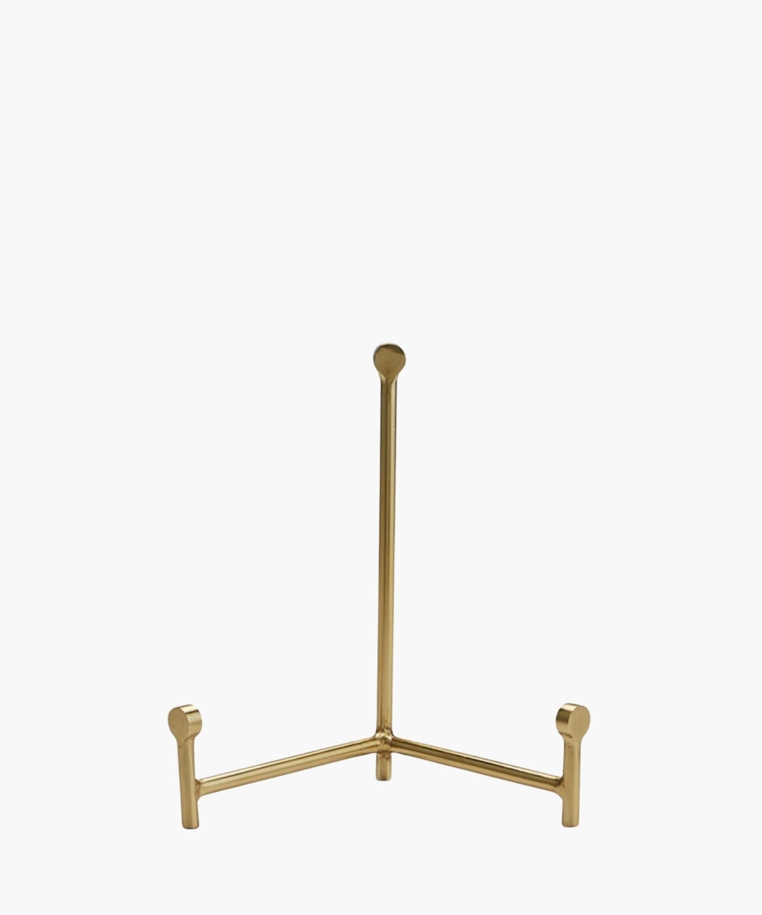 A sleek, gold easel with three legs, standing upright on a white background. The design is minimalistic, conveying elegance and simplicity. | SW Home