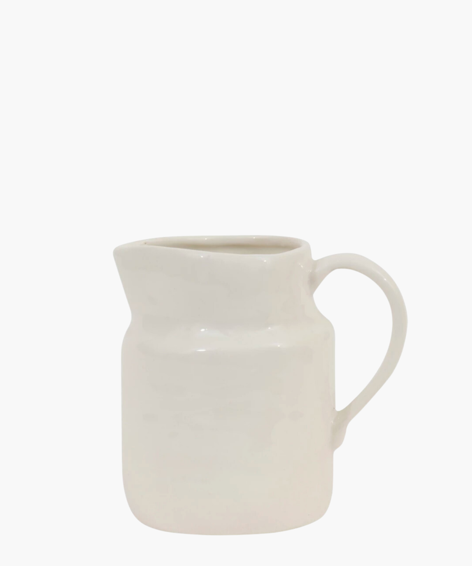 A simple, white ceramic creamer with a wide spout and curved handle against a plain background. It has a glossy finish, conveying a minimalist style. | S.W. Home
