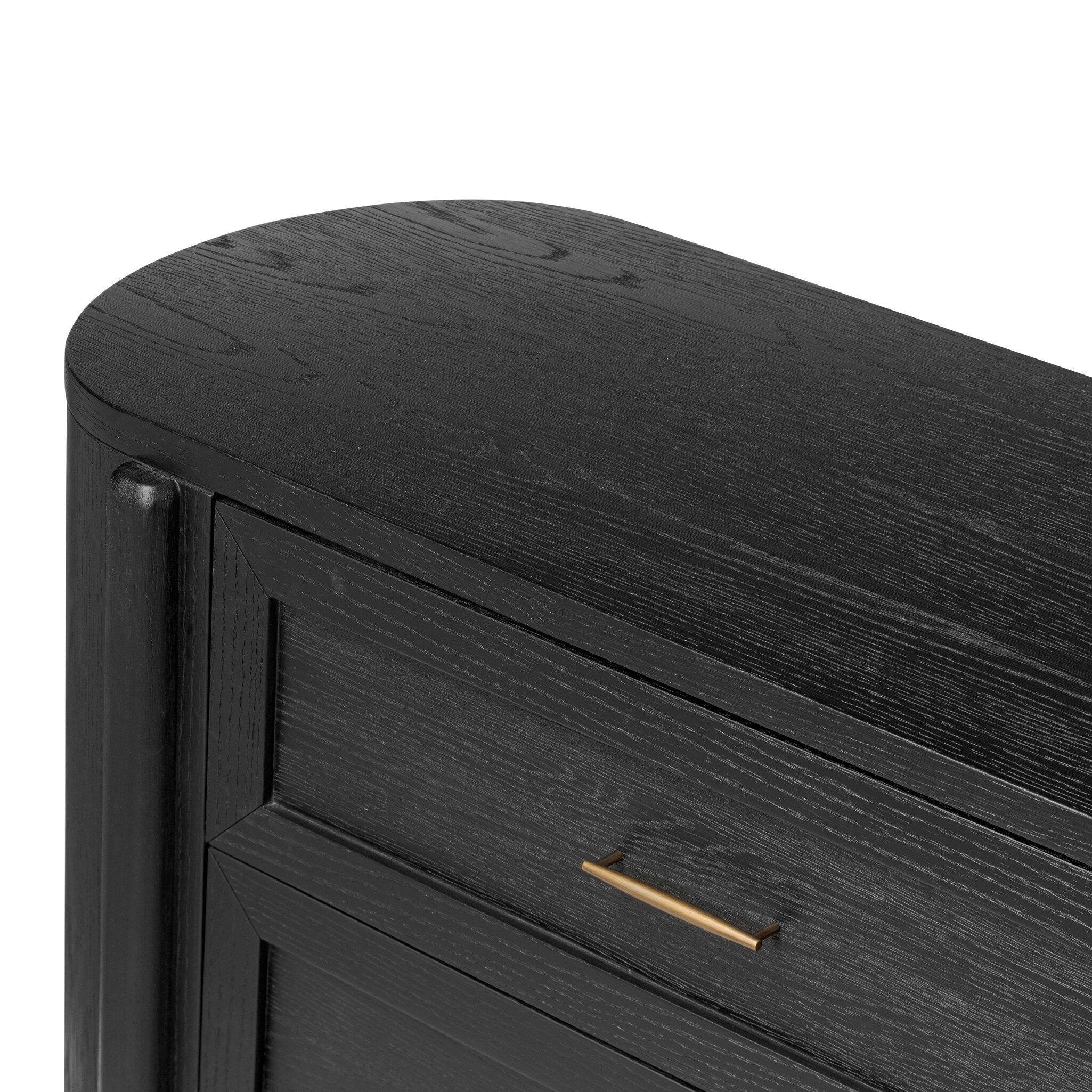 Close up of a curved black dresser with brass handles on a white background.