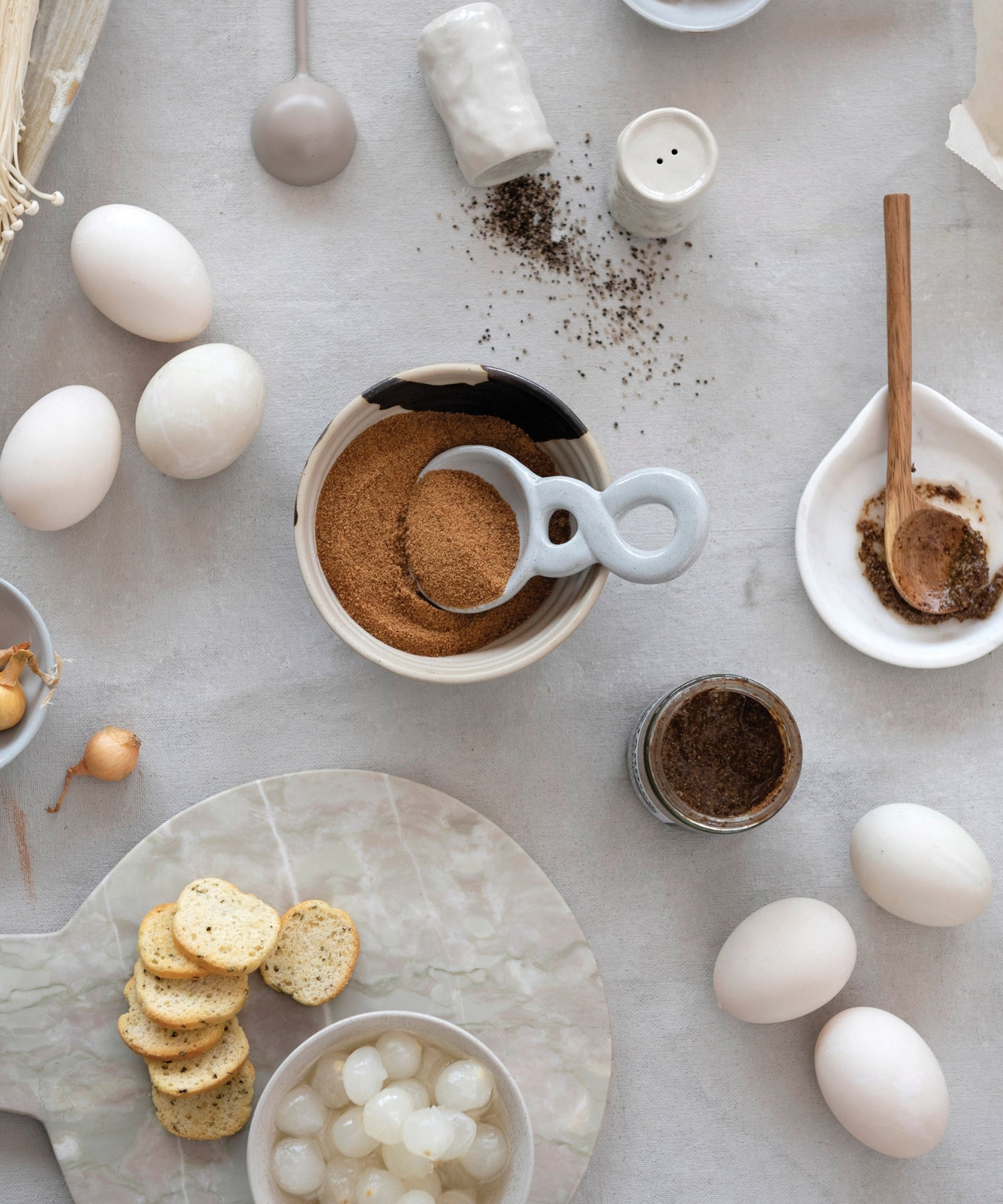 White stoneware ceramic spoon with twisted handle styled with kitchen wares. | Wildwood Home Co.