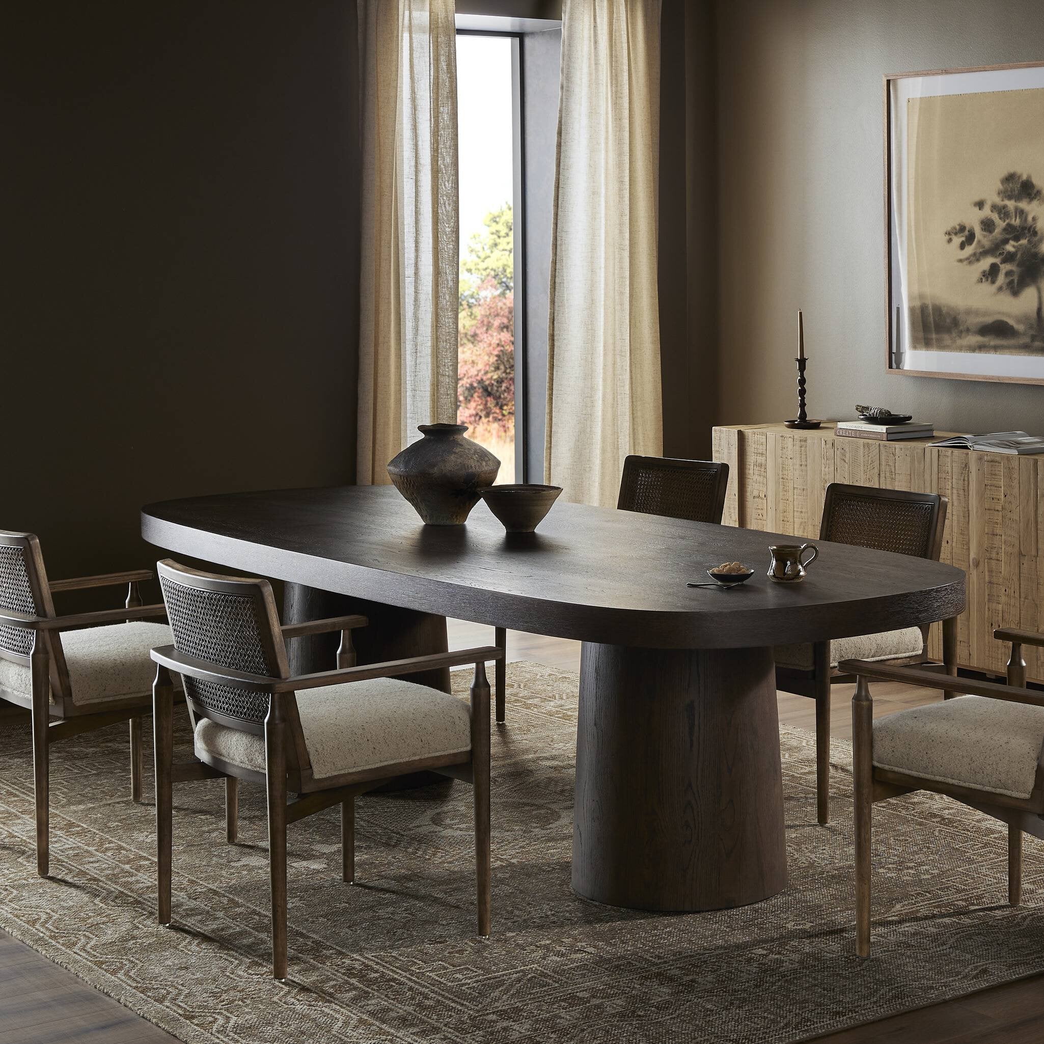 Dining room with a dark wooden table and chairs in a well-lit room. | Wildwood Home Co.