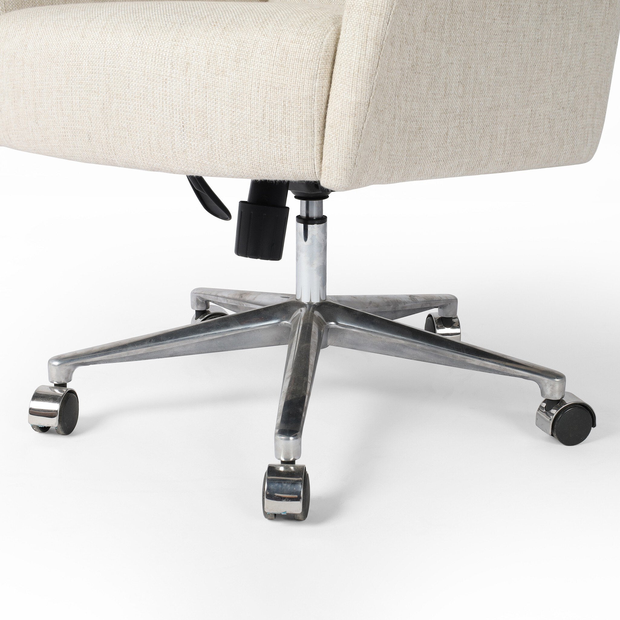 Close up of an ivory upholstered desk chair with a chrome base on a white background.