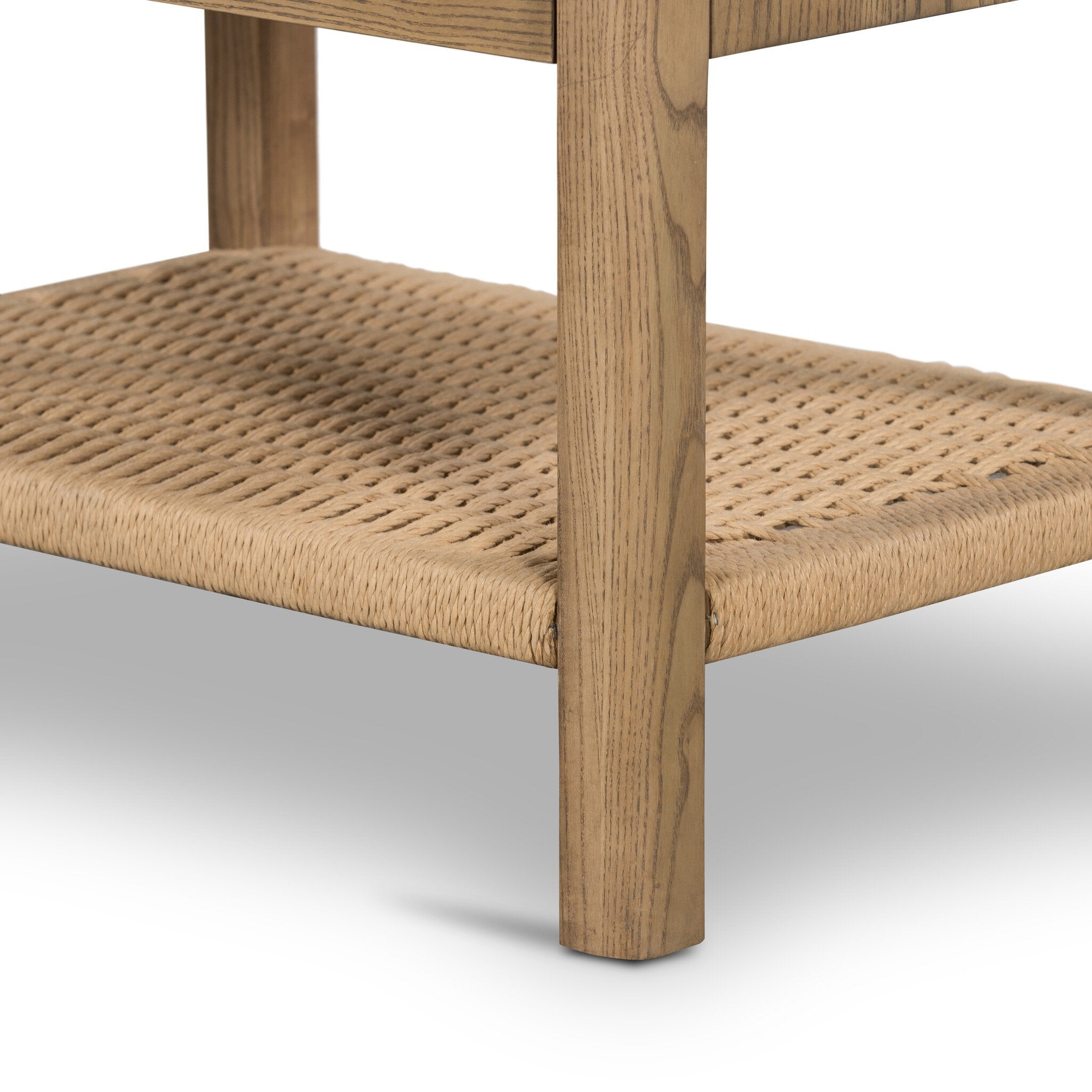 Close up of a wooden nightstand with two drawers and a woven shelf on a white background.