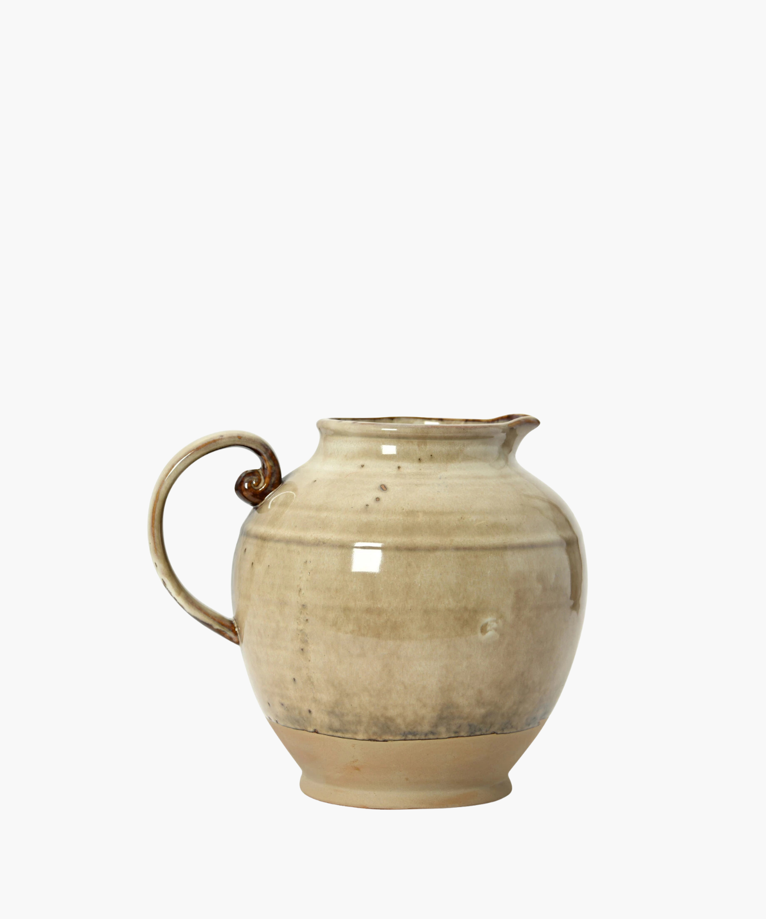 A beige ceramic pitcher with a rounded body, a curved handle, and a narrow spout. The glaze has subtle darker speckles, giving it a rustic feel. | S.W. Home
