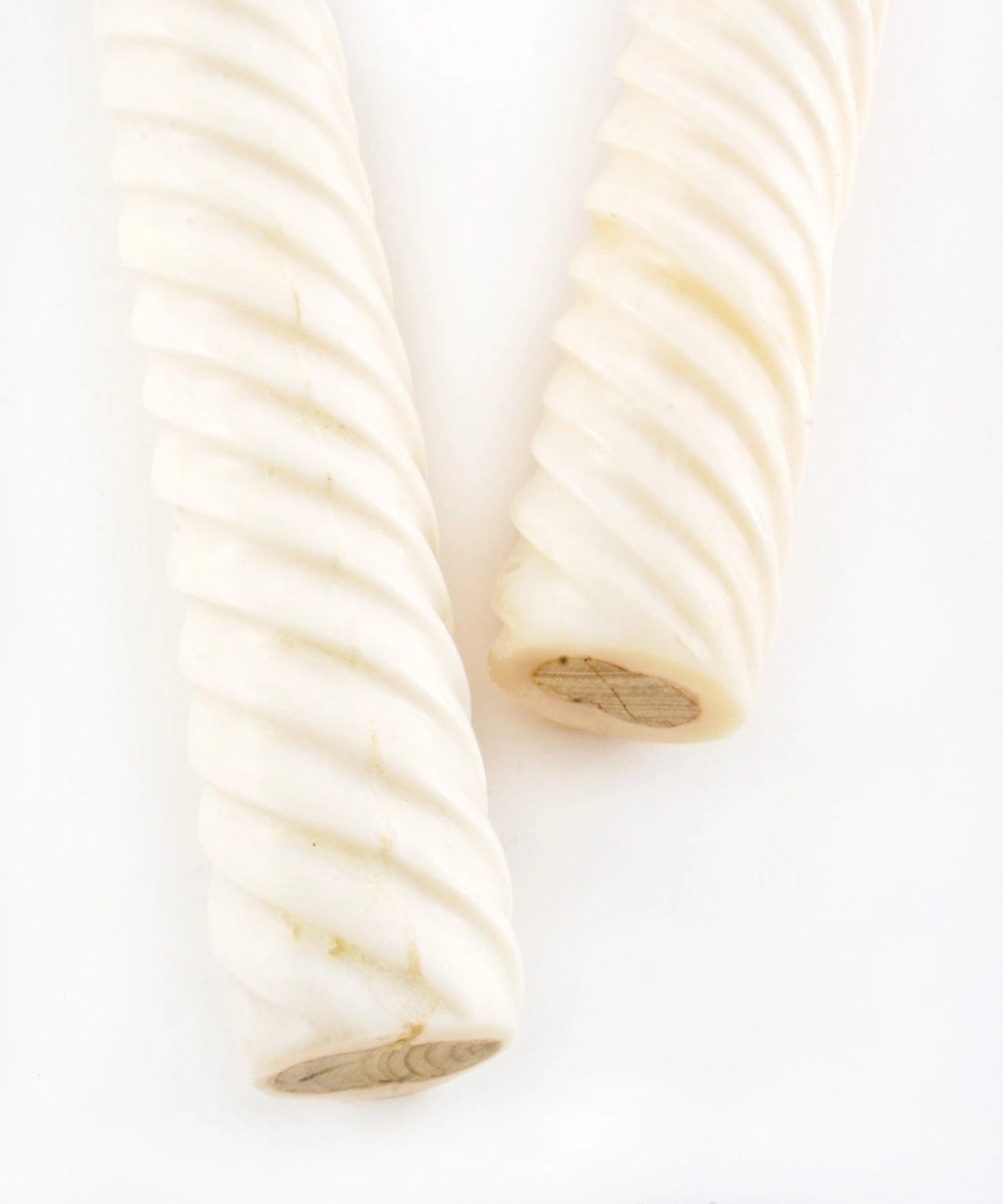 Close up of olive wood salad server featuring light brown heads and off-white bone textured handles. They convey a minimalist, natural aesthetic.