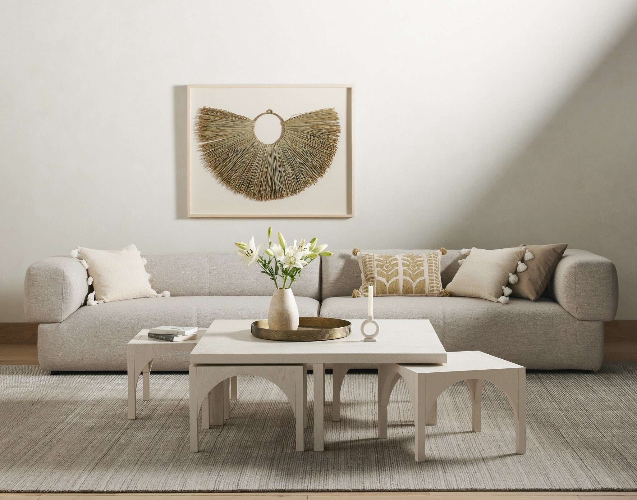Modern living room with a beige sofa, coffee table, and decorative elements. | SW Home