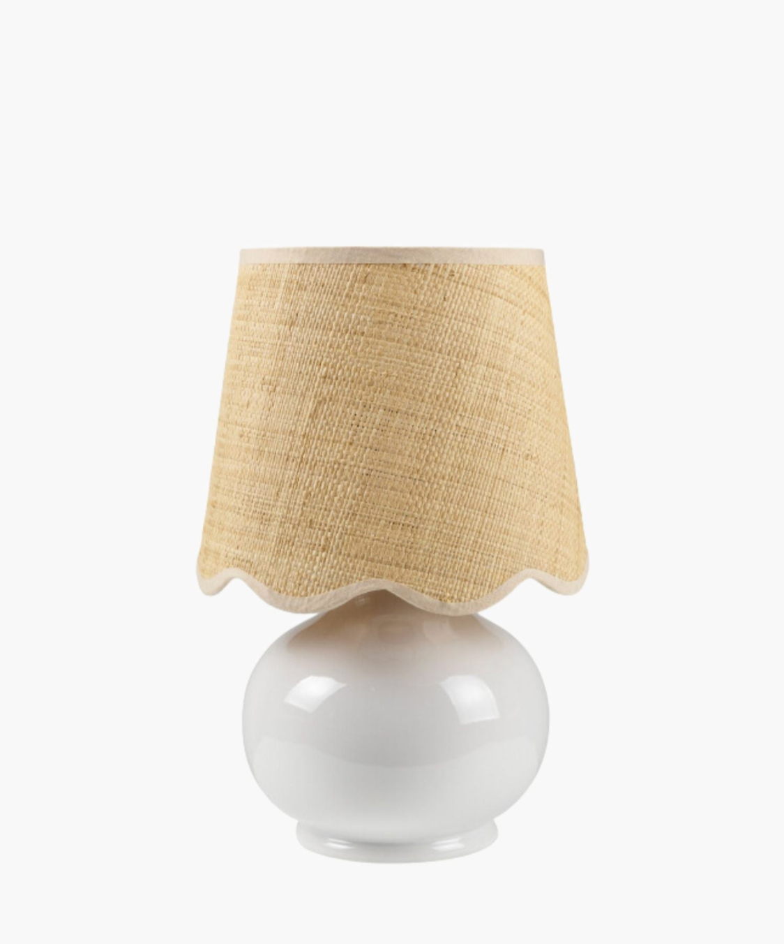 A white ceramic table lamp has a textured natural fiber shade with wavy edges. The design is simple and rustic, conveying a cozy feel. | S.W. Home