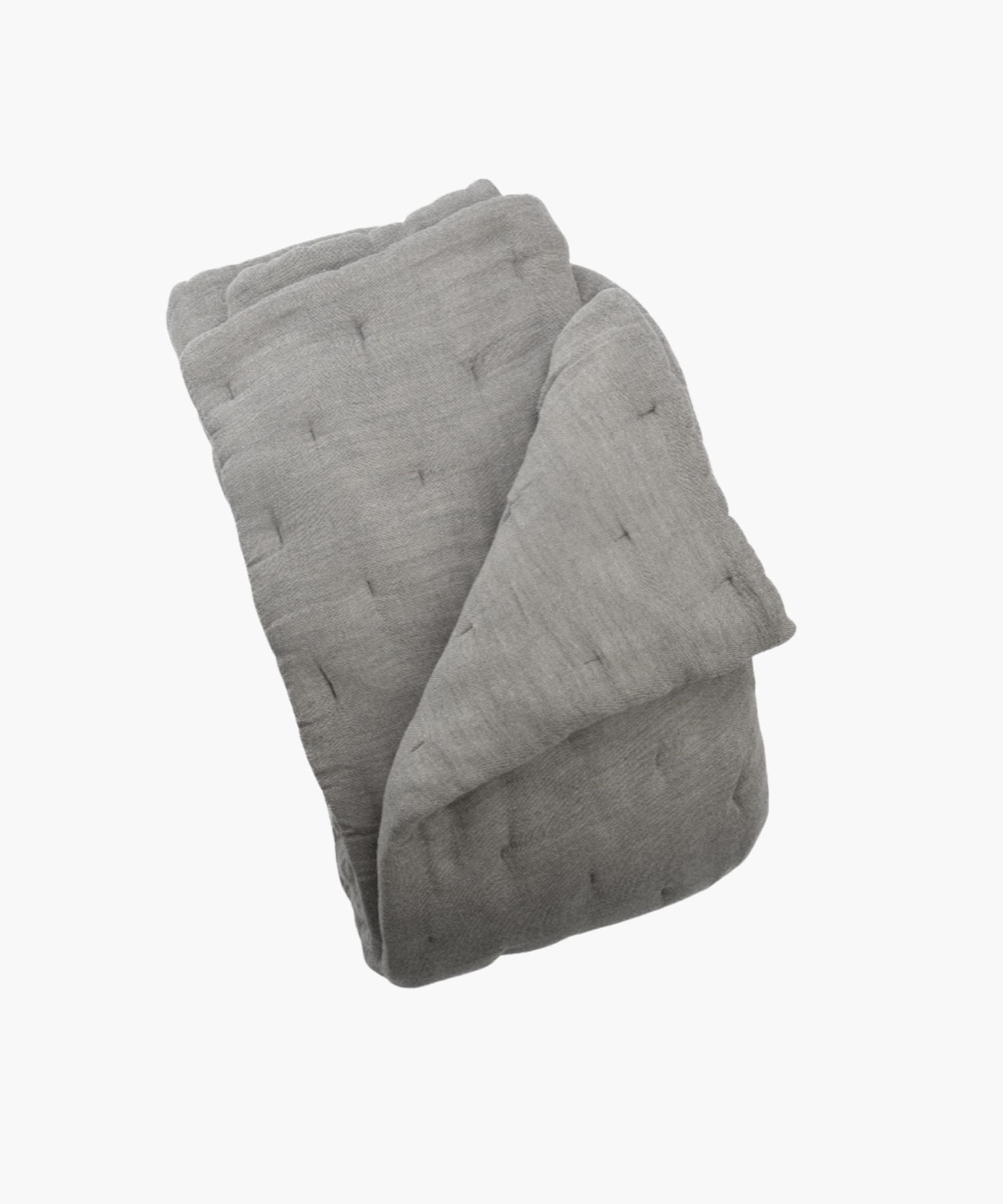 Folded gray quilt on a white background showing its fabric texture. | S.W. Home