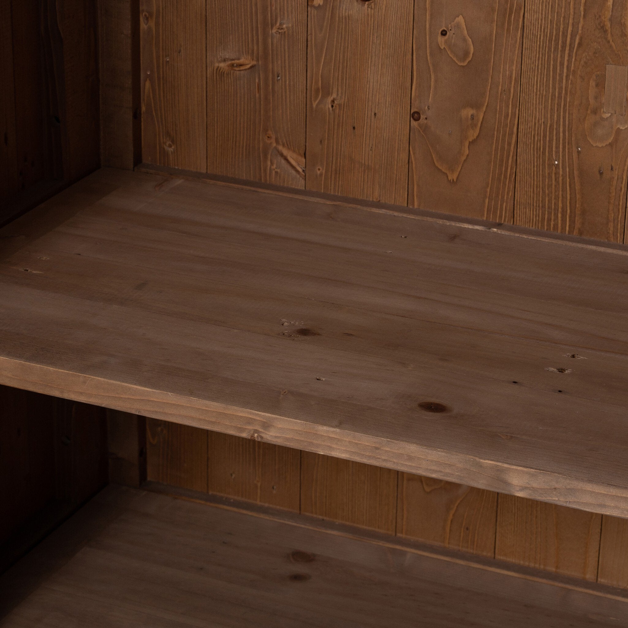 Close up of the inside of a wooden cabinet with two doors and rounded corners on a white background.