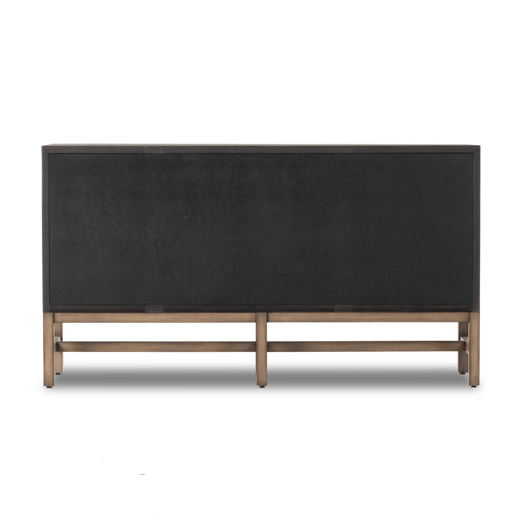 The back of a black dresser with brass knobs with wooden legs on a white background.