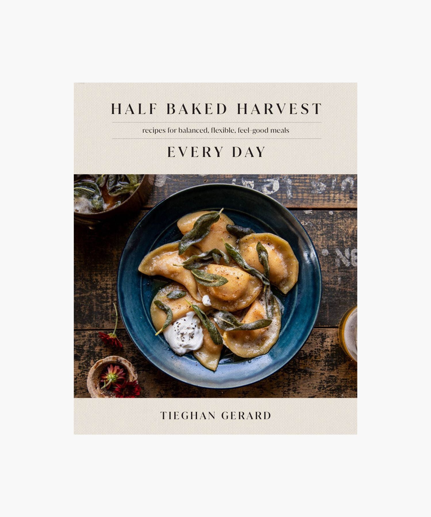 Cookbook cover titled "Half Baked Harvest Every Day" by Tieghan Gerard features a rustic, cozy image of ravioli with sage on a blue plate. | S.W. Home