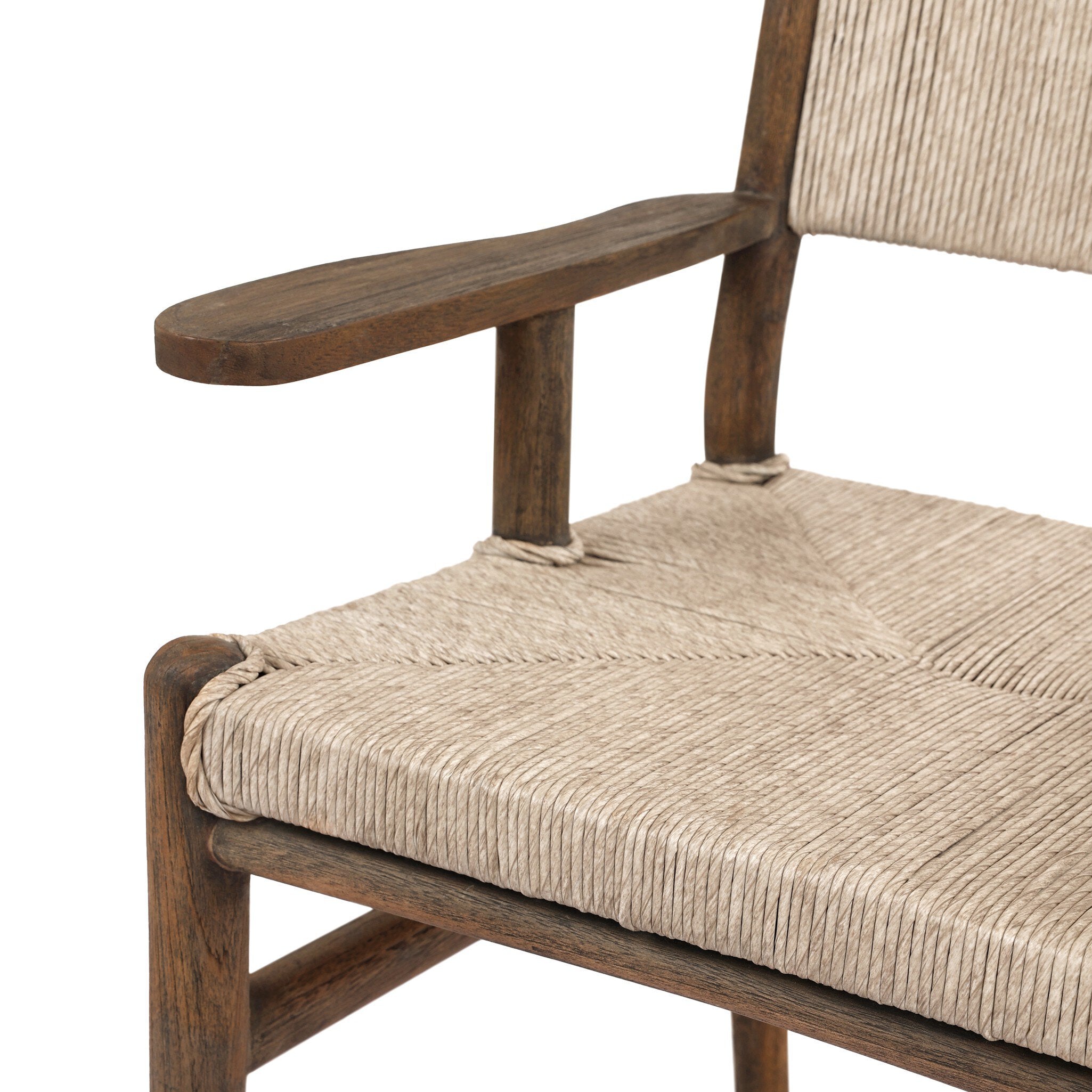 Close up view of a shaker style outdoor dining armchair with a dark brown wood frame and light brown woven seat and back on a white background. 