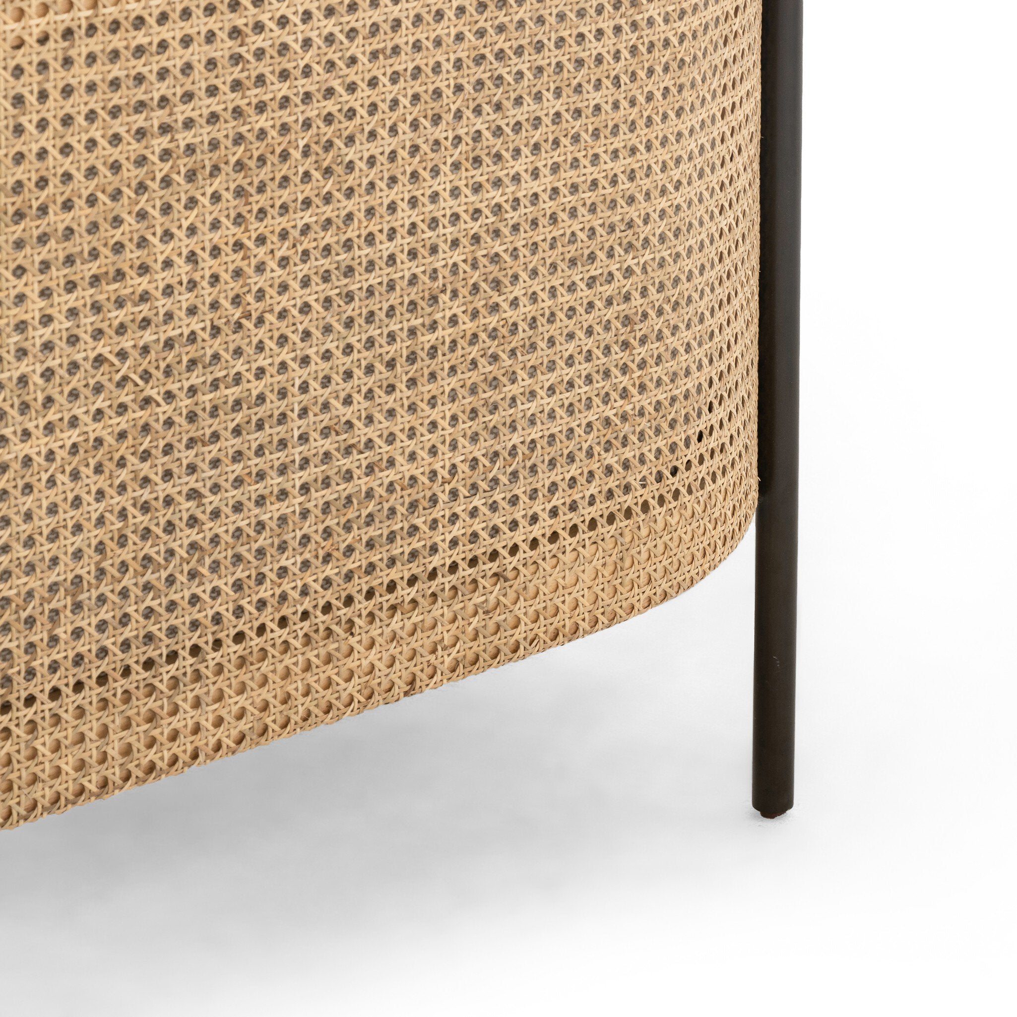 Close up of a beige armchair with dark metal legs on a white background.