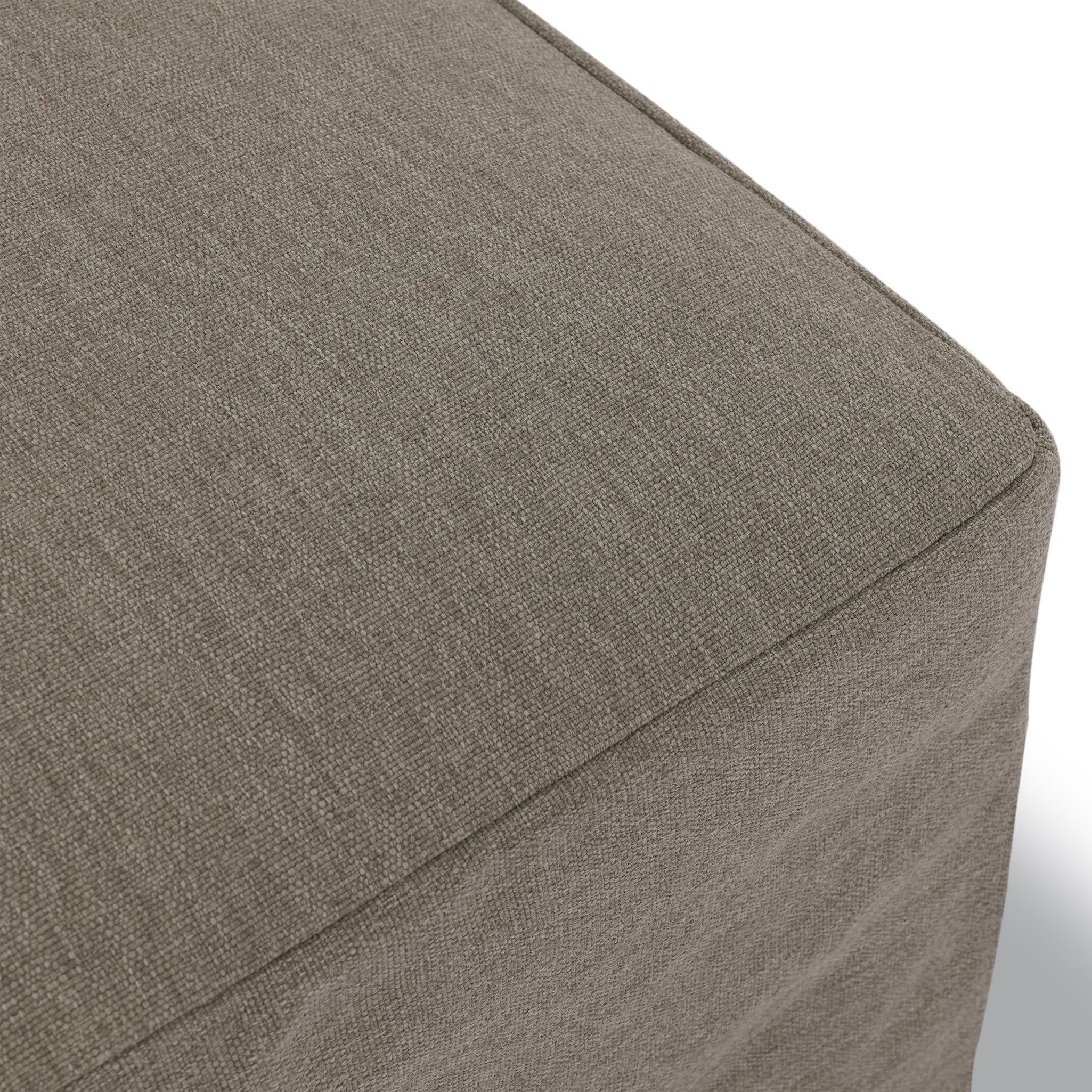Close up of a slipcover gray outdoor ottoman showing its color and fabric texture. 