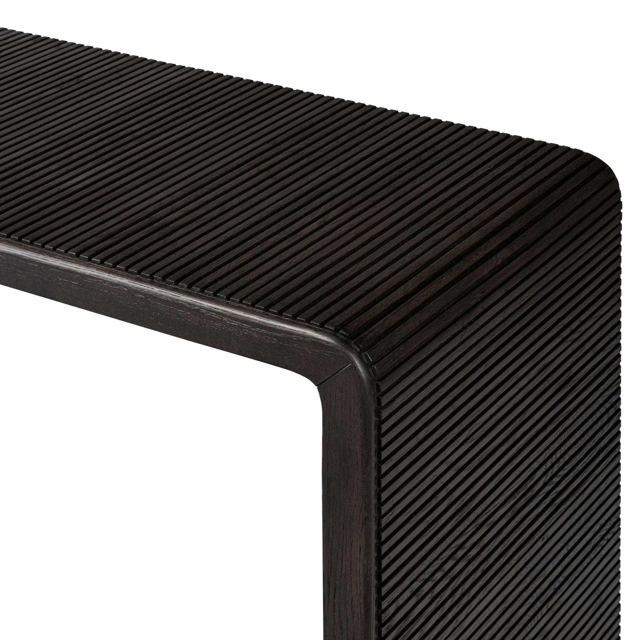 Close up of a smoked black oak console table with reeding and rounded edges on a white background.