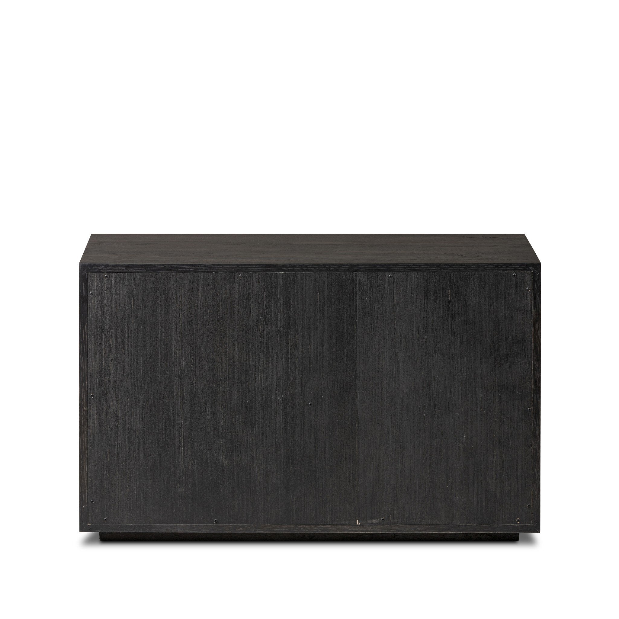The back of a dark wooden dresser with vertical reed detailing and three drawers on a white background.