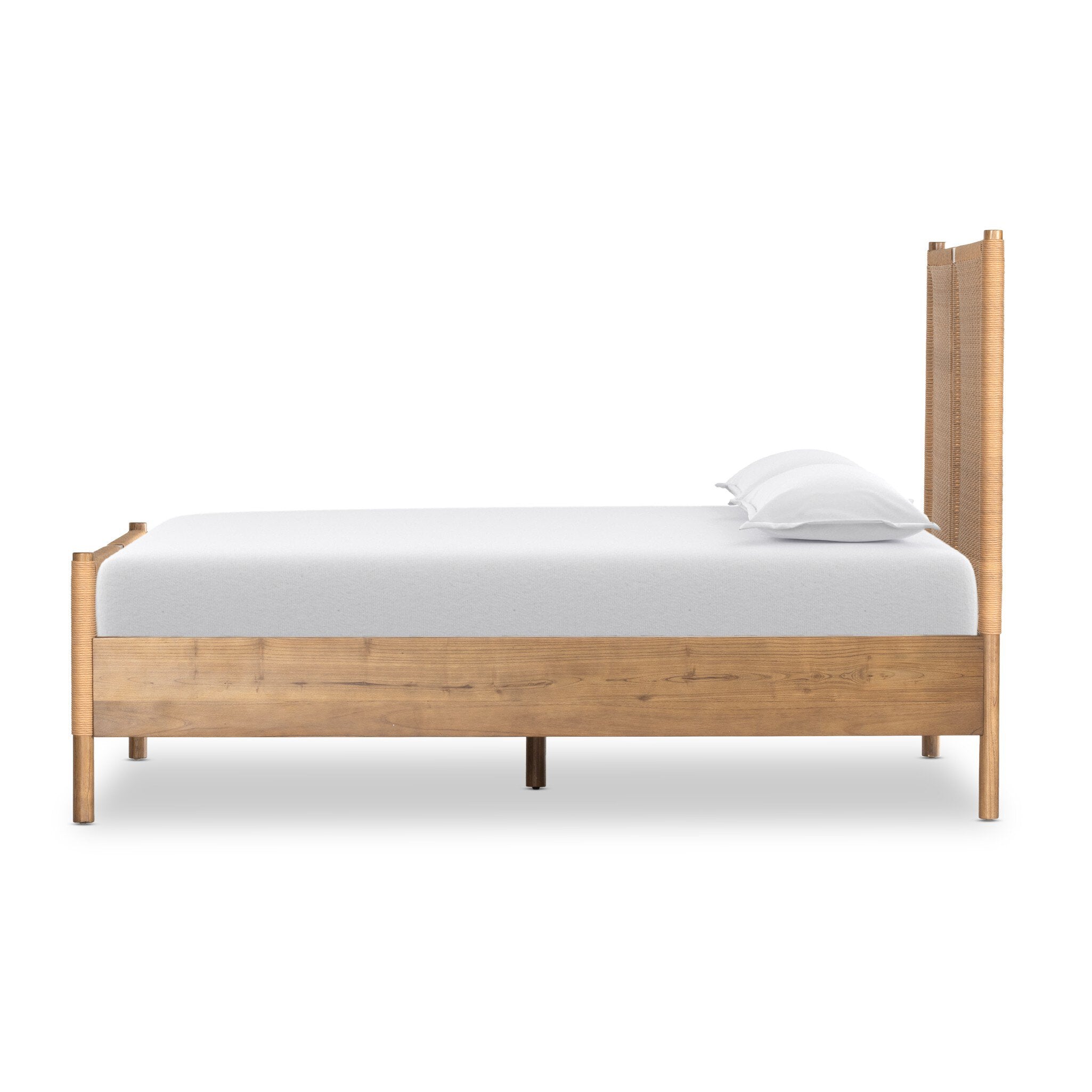 Side profile of a wicker bed with white bedding on a white background.