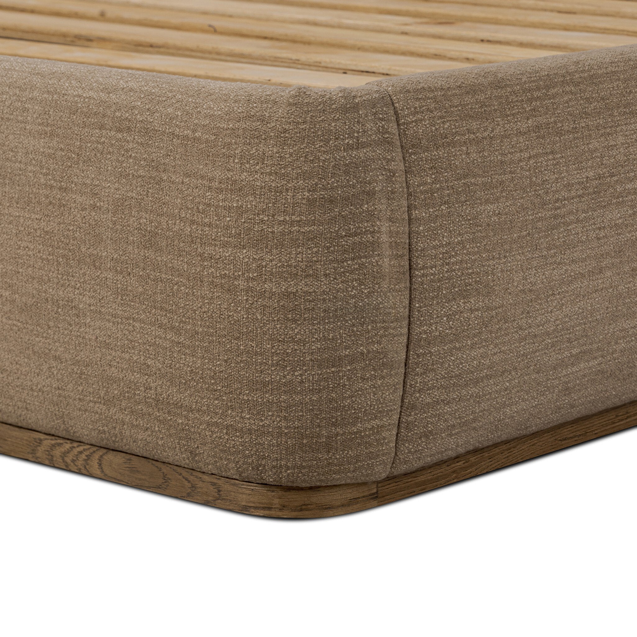 Close up of a taupe upholstered bed with white bedding on a white background.