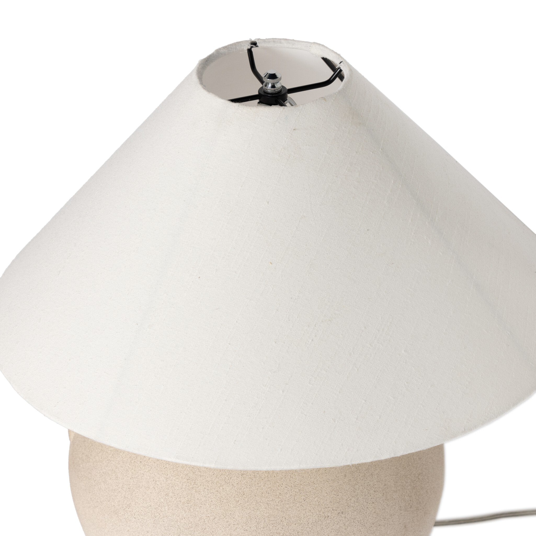 Beige ceramic table lamp with an ivory lampshade on a white background.