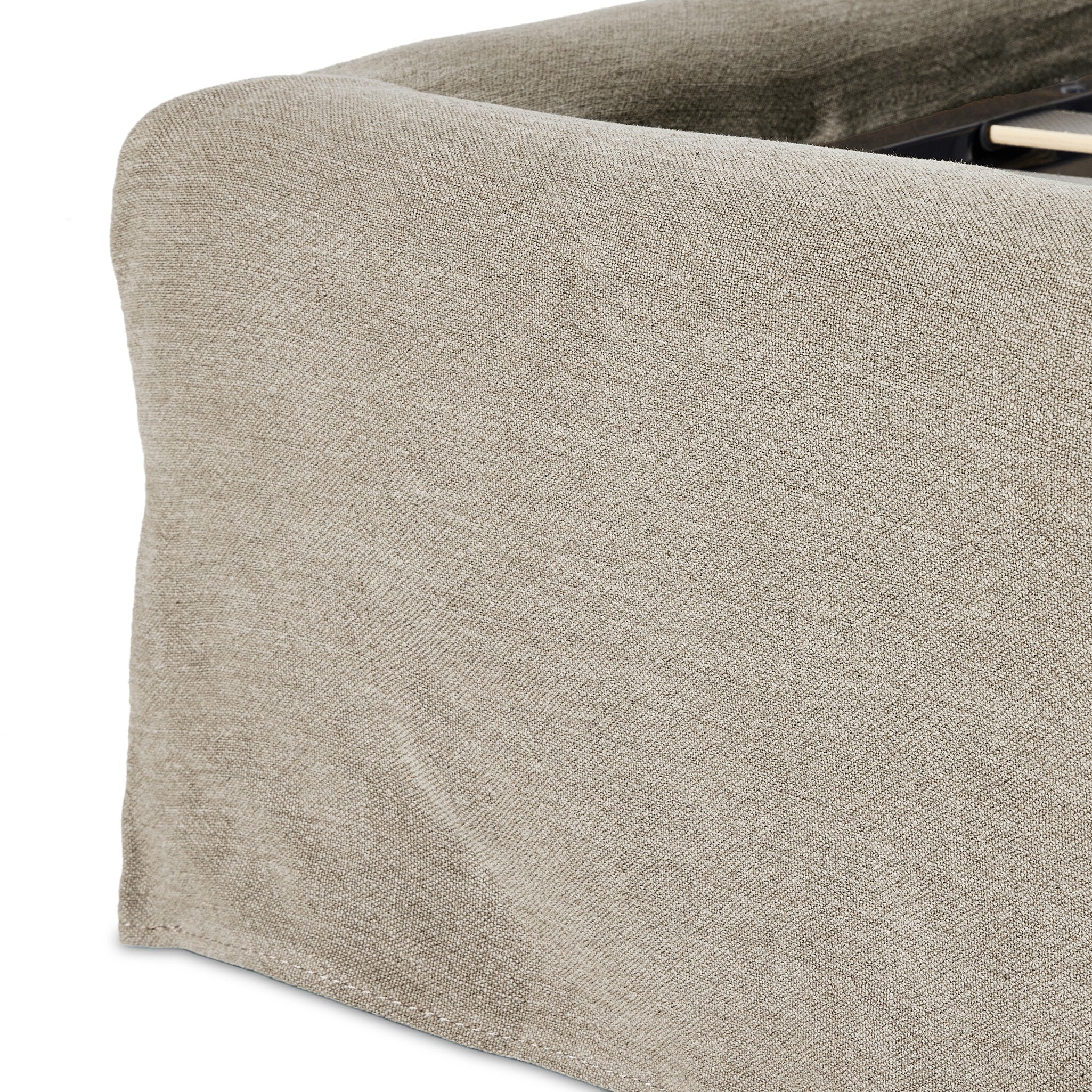 Close up of a beige upholstered bed with white bedding on a white background.