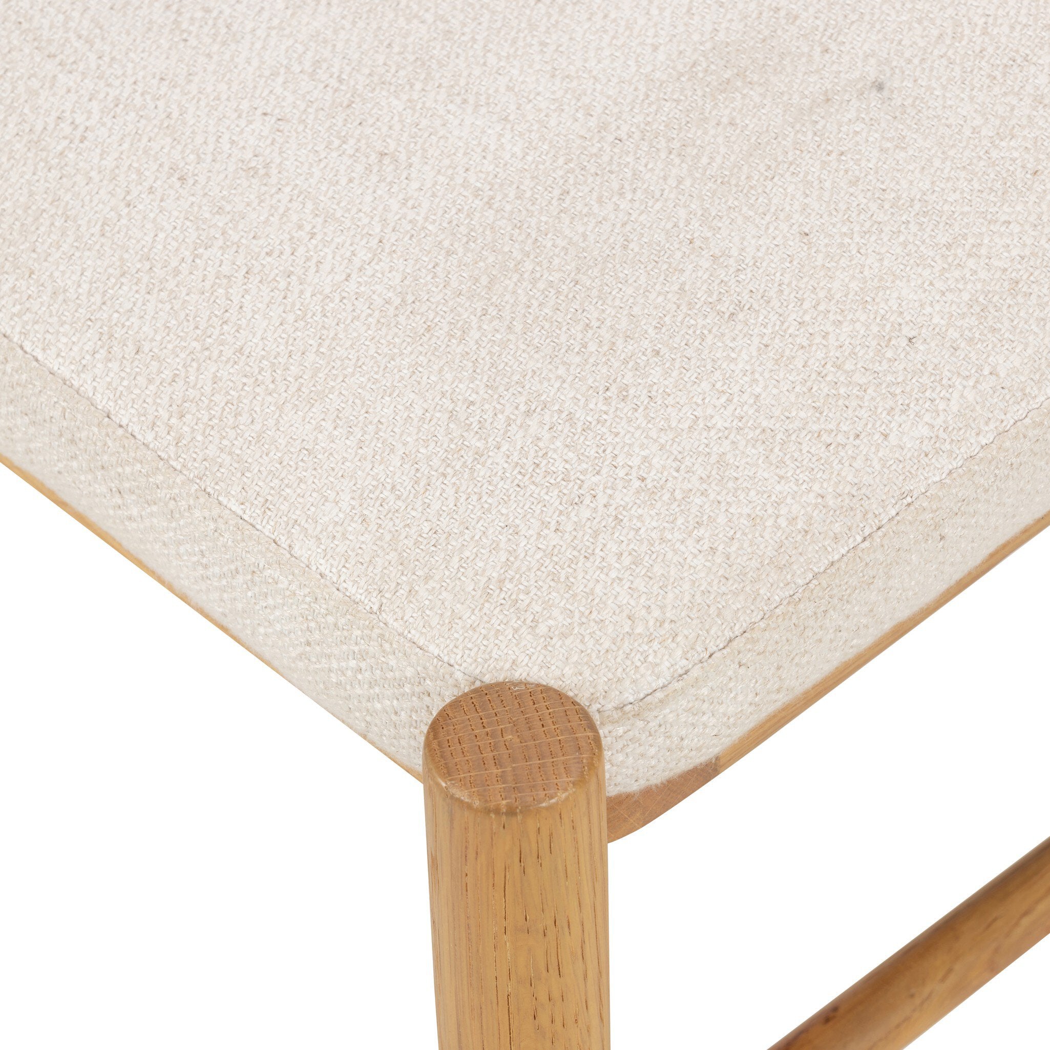 A close up of a solid oak dining chair with an arched frame, hand-wrapped cane back detailing, and an upholstered drop-in seat. 