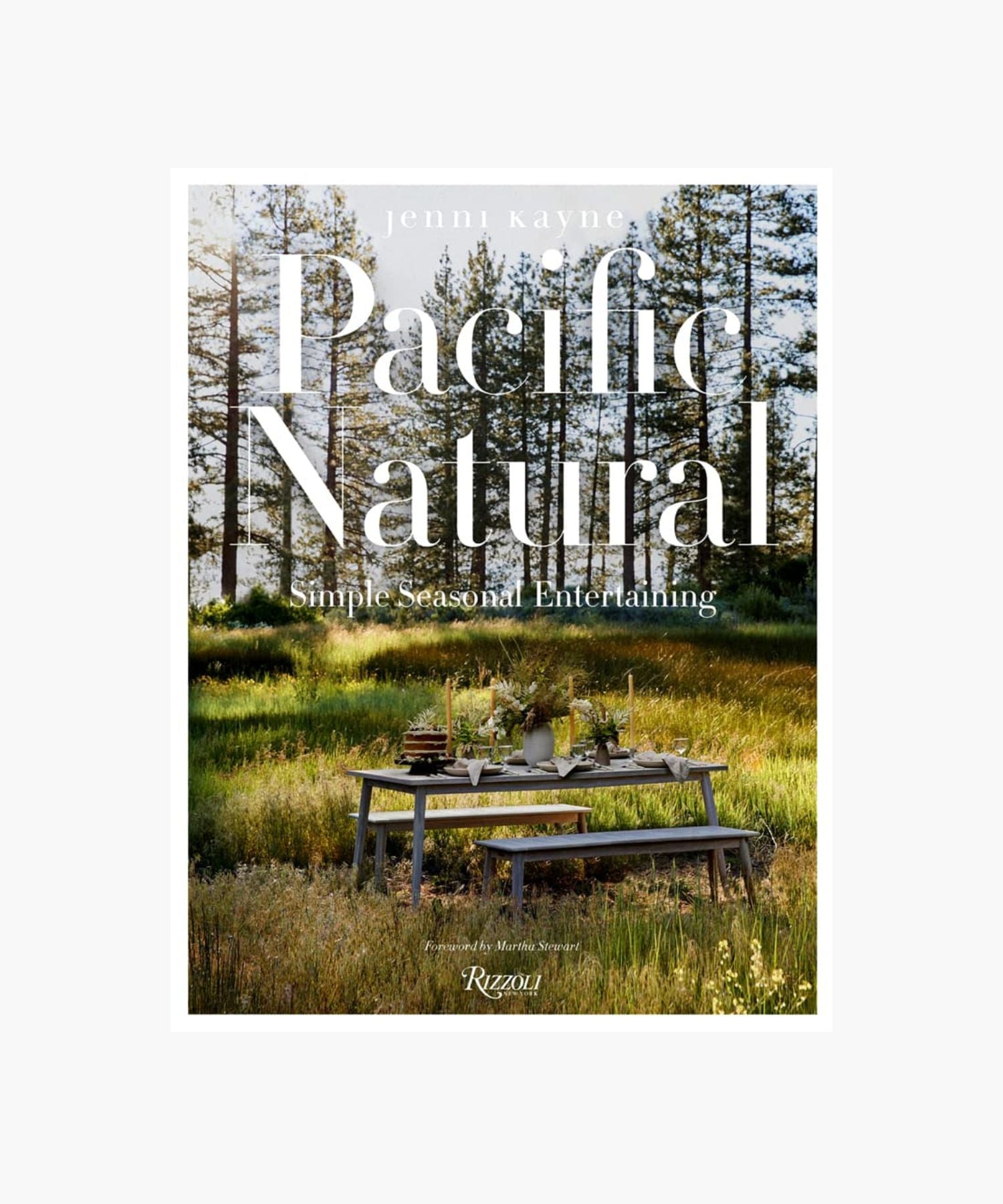 The cover of the book "Pacific Natural" by Jenni Kayne featuring a serene outdoor picnic scene with a rustic table set in a sunlit forest, conveying tranquility and elegance. | S.W. Home