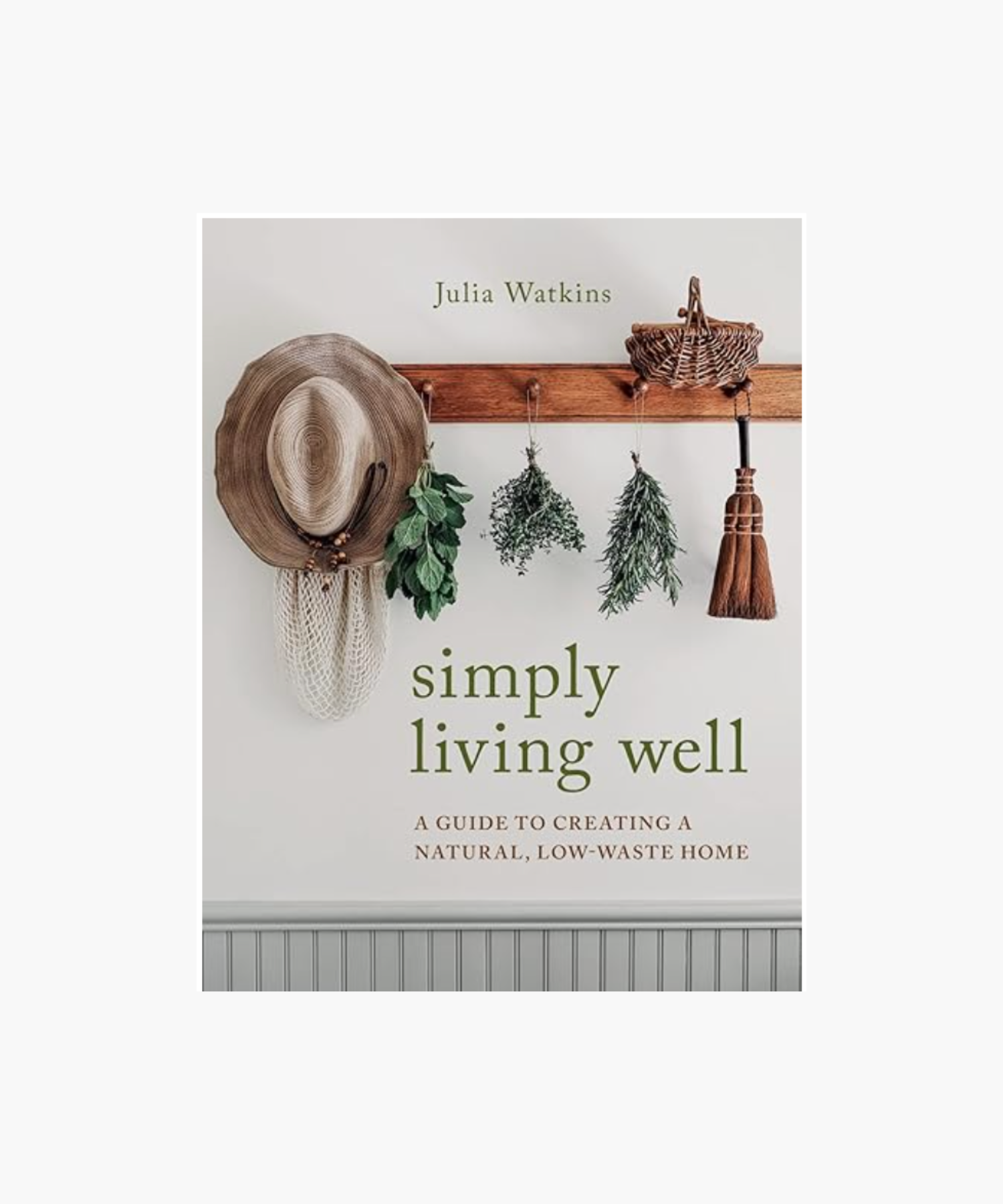 A book cover titled "Simply Living Well" by Julia Watkins, featuring a rustic wooden peg rail with a straw hat, herbs, basket, and broom hanging. The design conveys a natural, low-waste lifestyle theme. | S.W. Home