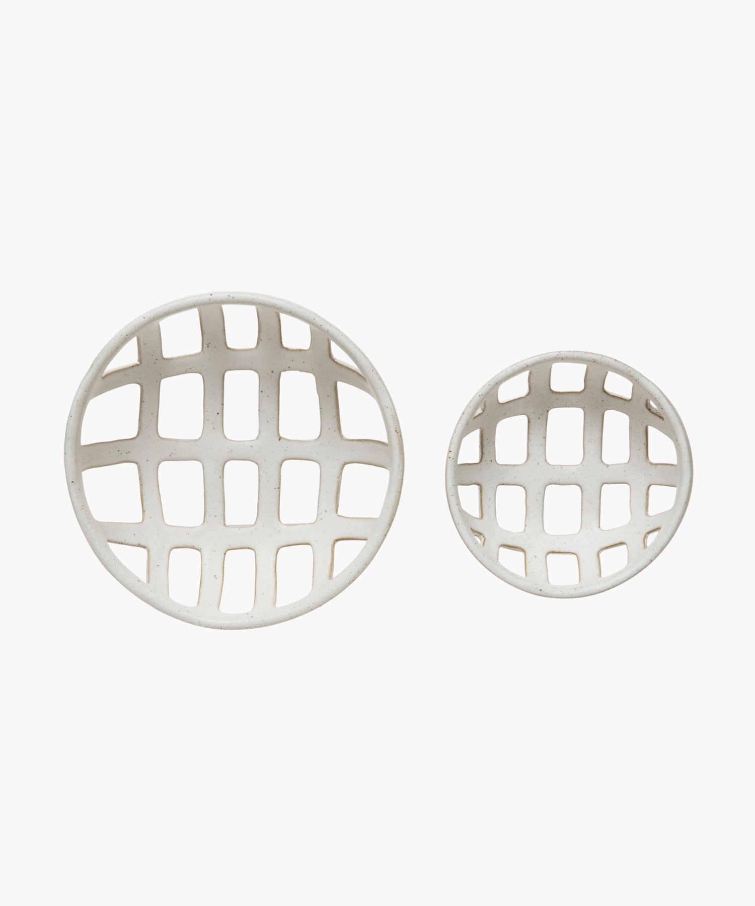 Overhead view of two openwork stoneware ceramic bowls with a white reactive glaze finish, one larger than the other, featuring an airy, lattice-like design. The tone is minimalist and modern. | S.W. Home