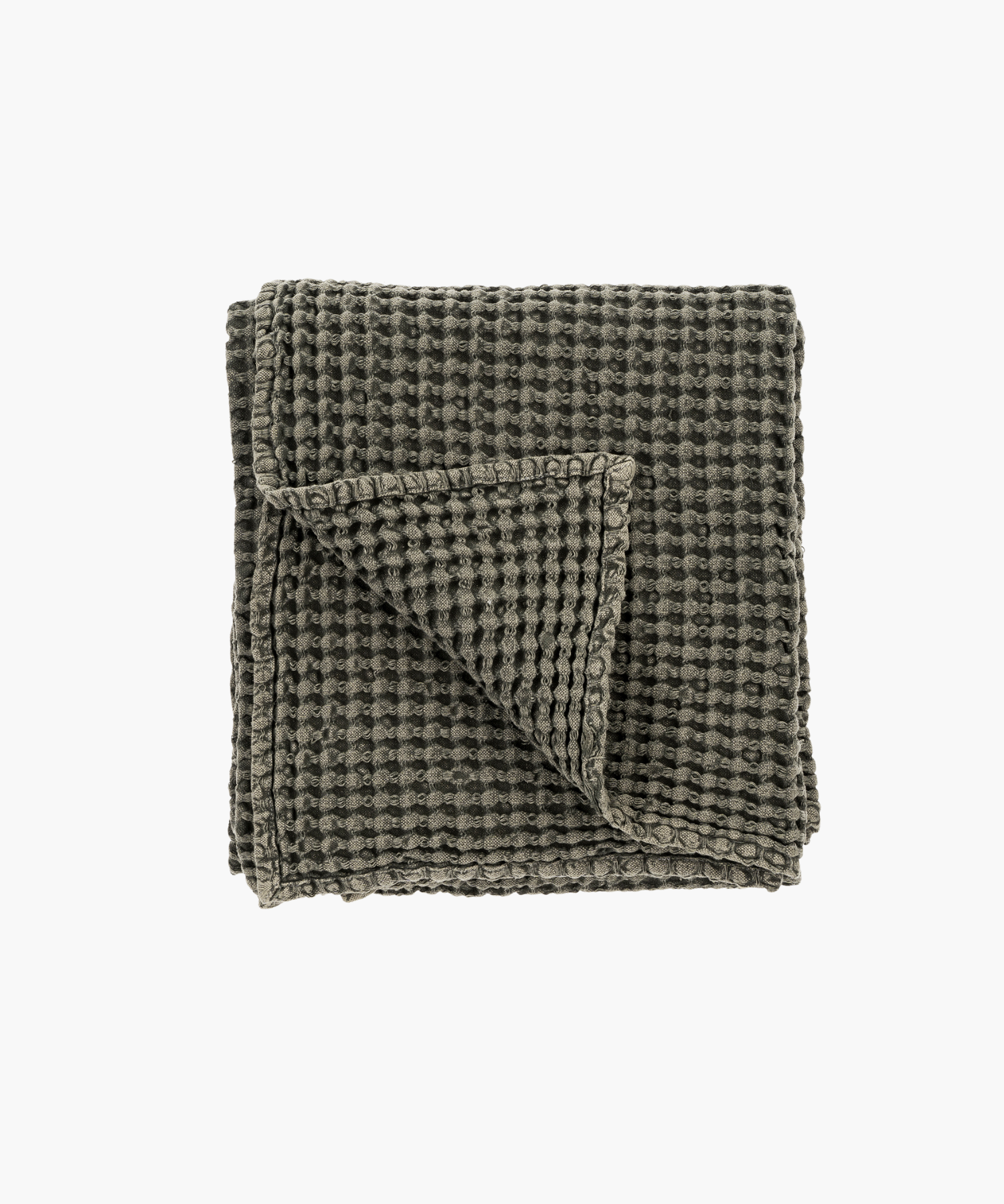 Dark gray or charcoal waffle weave throw blanket, neatly folded with one corner flipped over, showcasing its textured, cozy fabric on a plain white background. | S.W. Home