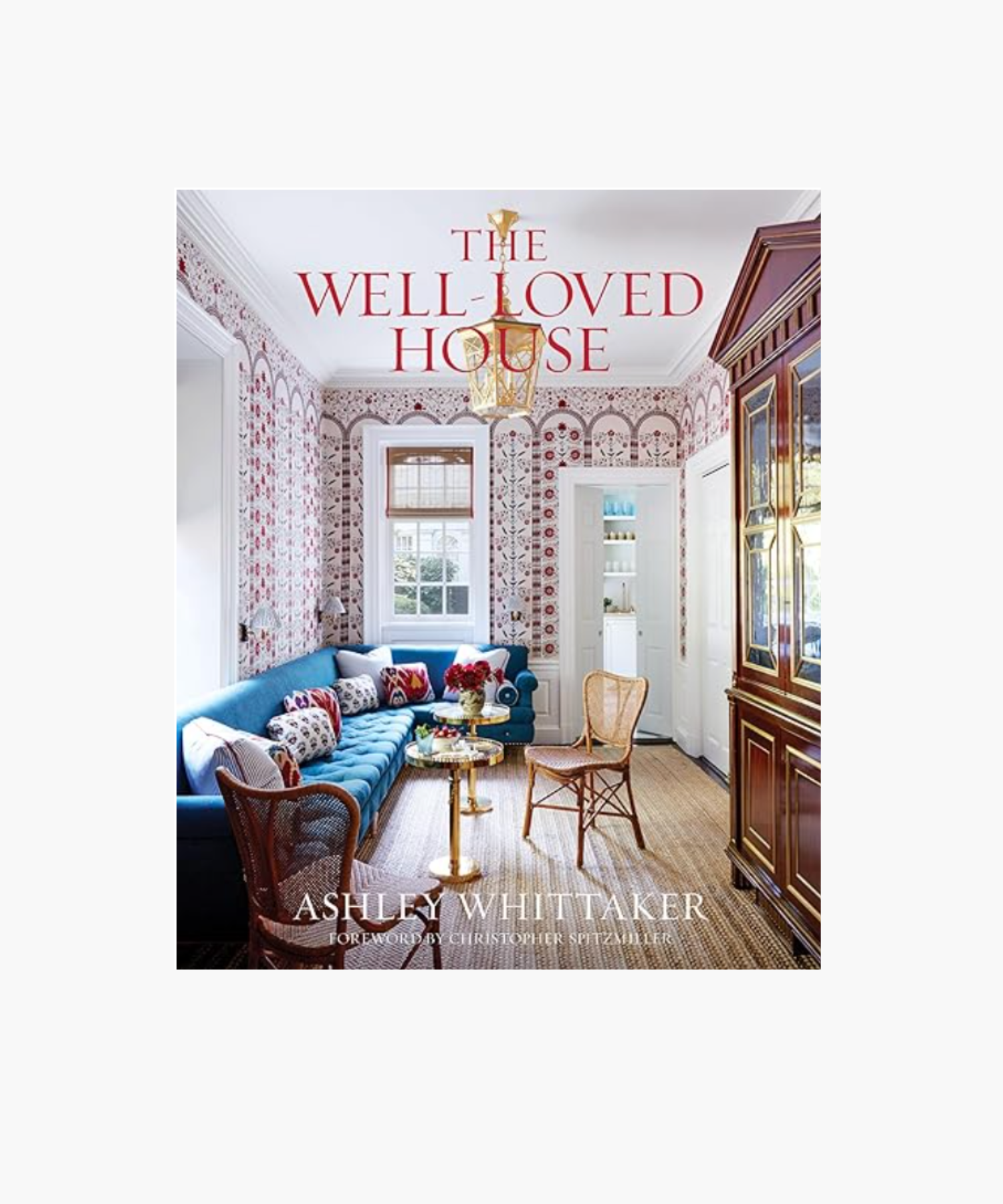 Cover of "The Well-Loved House" by Ashley Whittaker. Features a vibrant living room with a blue sofa, colorful pillows, patterned wallpaper, and a gold chandelier. | S.W. Home