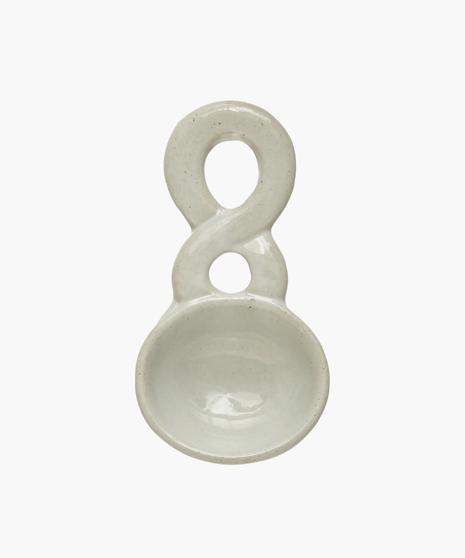 White stoneware ceramic spoon with a smooth, glossy finish. The design resembles an infinity symbol on the handle, conveying elegance and simplicity. | Wildwood Home Co.