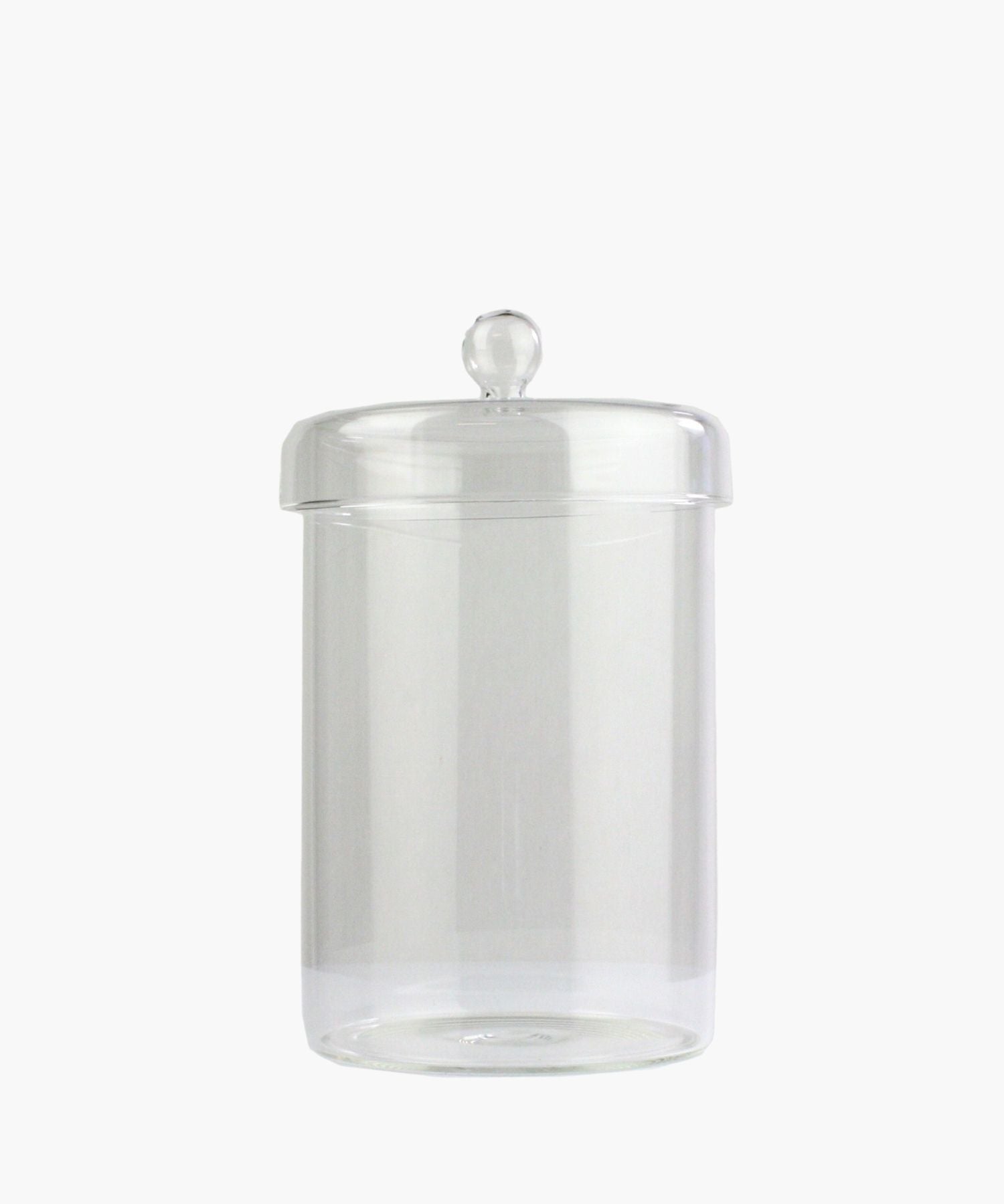 A clear glass jar with a round lid and a knob handle is centered on a plain white background. The jar is empty, conveying simplicity and elegance. | S.W. Home