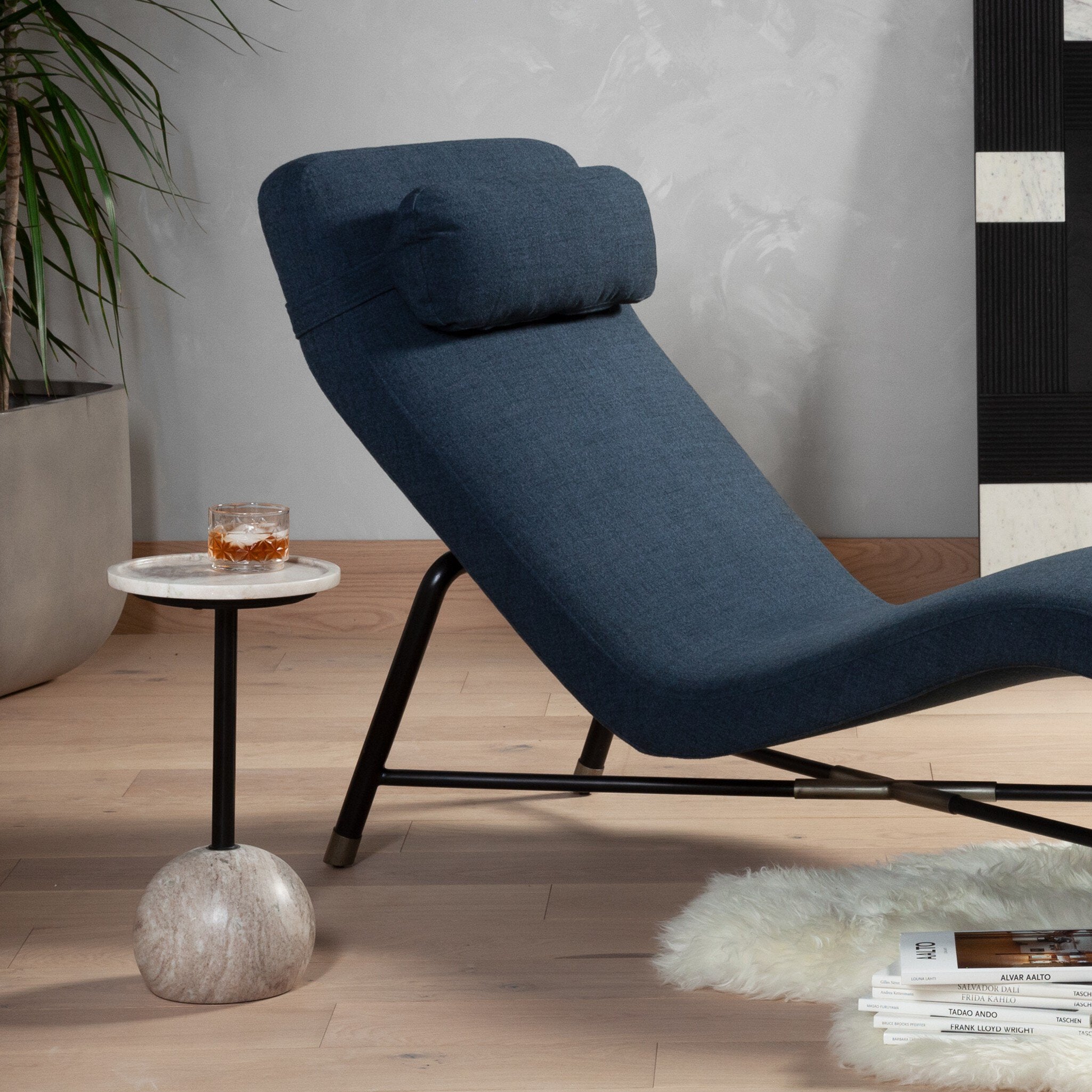 Blue lounge chair in a modern living room setting with a side table and books. | Wildwood Home Co.