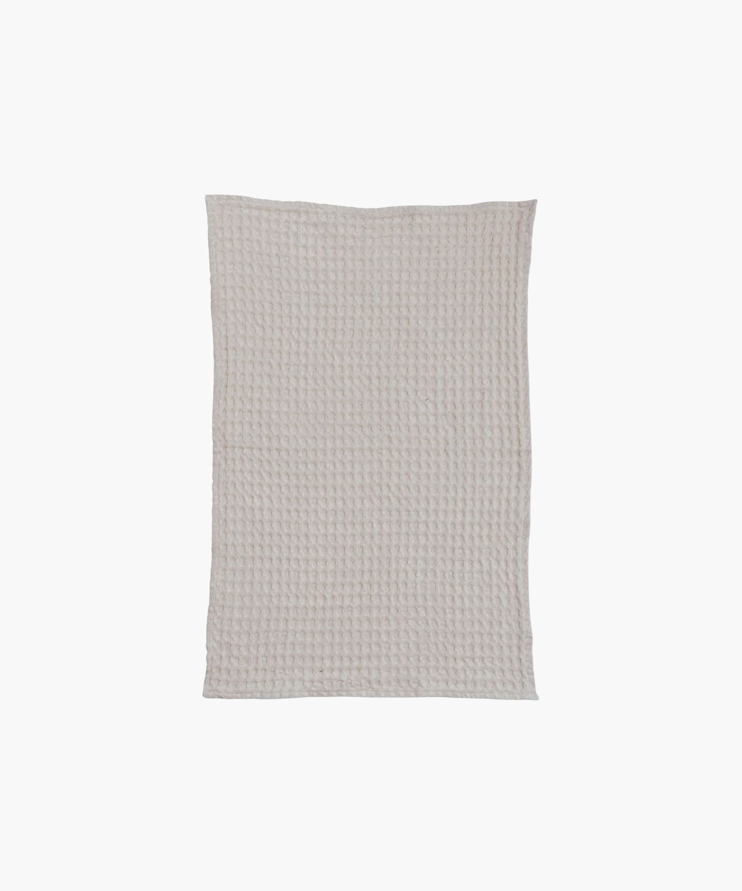 A cream colored, rectangular waffle-weave tea towel with visible texture and a clean, simple appearance. | Wildwood Home Co.