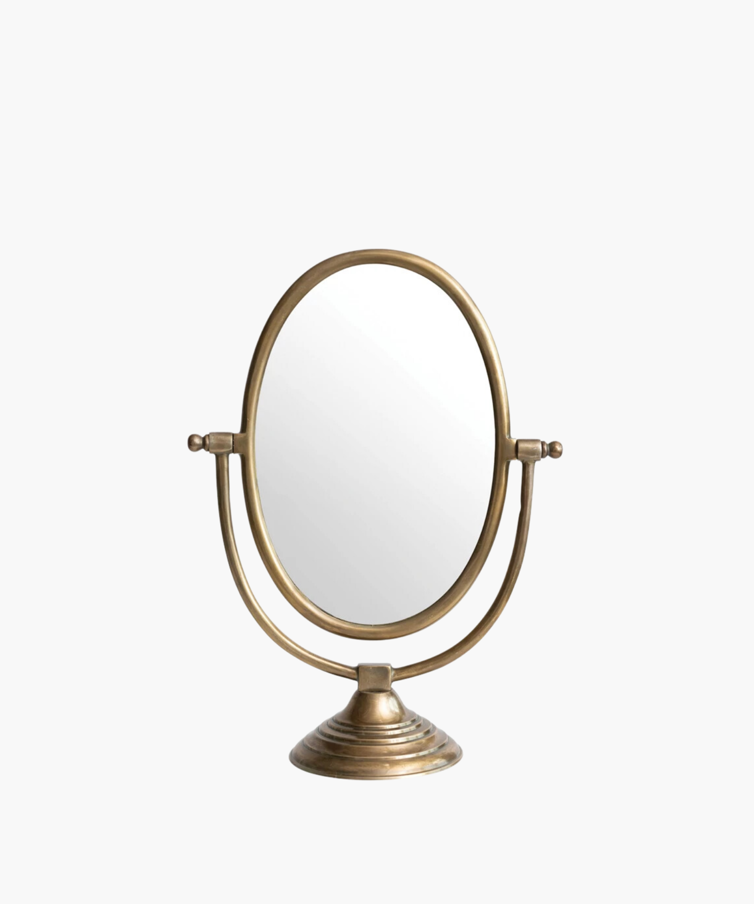 A vintage-style tabletop mirror with an oval shape and bronze finish. It features an adjustable frame resting on a decorative, circular base. | S.W. Home
