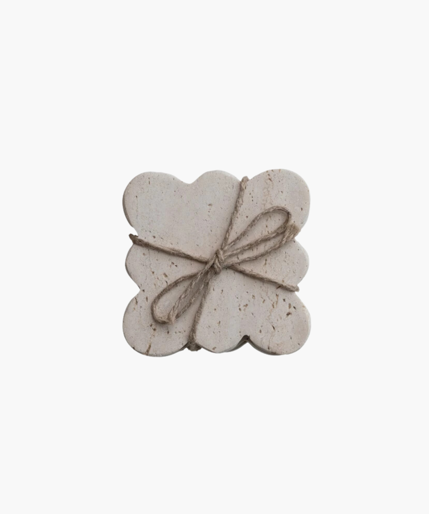 Travertine rectangular coasters with scalloped edges, wrapped in rustic twine tied in a bow. The coasters have a natural, textured appearance, evoking simplicity. | S.W. Home